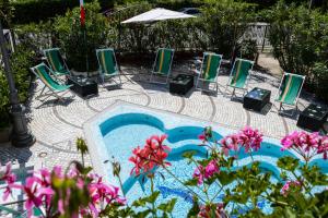 里米尼艾斯德拉酒店的一组椅子和一个鲜花游泳池