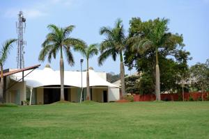 罗纳瓦拉杜克斯度假村的一座棕榈树在田野前的建筑