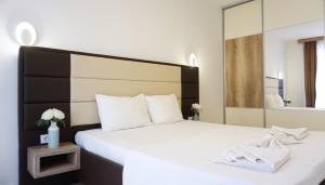 乌尔齐尼Ponte Apartments的卧室配有一张白色的床和大镜子