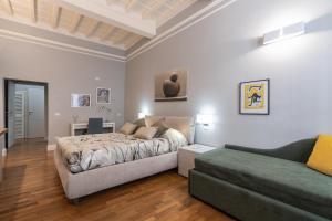 佛罗伦萨Firenze Rentals Deluxe Corso 5的一间卧室配有一张床和一张沙发