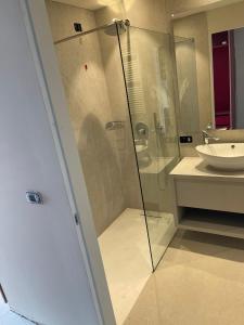 利莫内-苏尔加达LLAC Living Nature Hotel的一间带玻璃淋浴和水槽的浴室