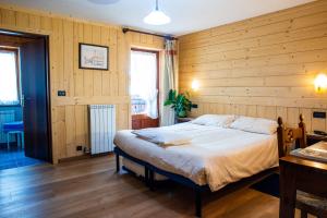 尚波吕克圣塔桑酒店的卧室配有一张木墙内的大床
