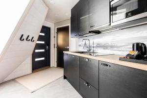 罗瓦涅米Glass Resort的厨房配有黑色橱柜和水槽