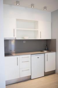 普拉亚登博萨波拉波拉公寓 - 仅限成人的白色的厨房配有白色橱柜和水槽