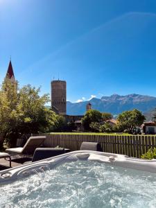 马莱斯韦诺斯塔蒂罗尔酒店的一个带椅子的热水浴池和一个城堡
