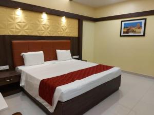 库姆巴科纳姆sri balaji grand hotel的一间卧室,卧室内配有一张大床