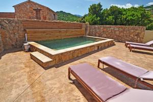 孔卡Bergeries de charme Caselle di Conca的一座带石墙和石头的游泳池