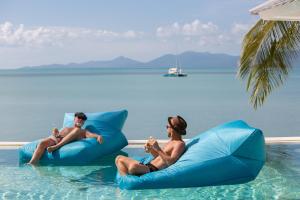 苏梅岛Tembo Beach Club & Resort的两个人坐在水里充气器上