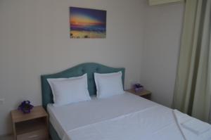 内塞伯尔Divela 3 Apartments的一张带白色枕头的床和一张墙上的照片