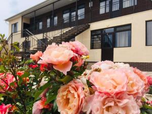 乔尔蓬阿塔Guest House Janel的大楼前的一大束粉红色玫瑰