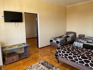 乔尔蓬阿塔Guest House Janel的客房设有两张床和一台平面电视。