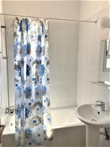 帕福斯Ariadne Apartments的浴室设有蓝色和白色的浴帘和水槽