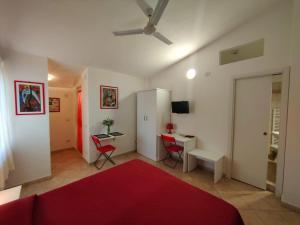 里卡迪Gullo Capo Vaticano的客厅配有红色的床和书桌