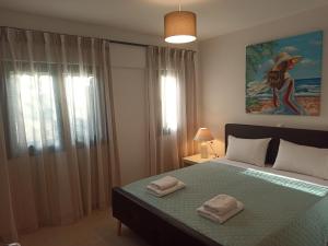 斯泰洛米诺斯Sea melody apartments的一间卧室配有一张床,上面有两条毛巾
