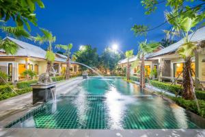 七岩Tontan Resort Cha-am的一座带喷泉的房屋前的游泳池