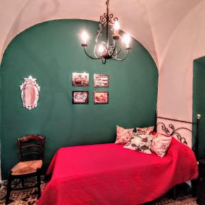 Santa AmaliaCasa Rural Maribel的一间卧室设有一张红色的床和绿色的墙壁