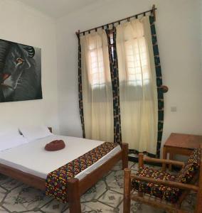 帕杰SawaSawa Lodge Paje的一间卧室配有一张床和一把椅子