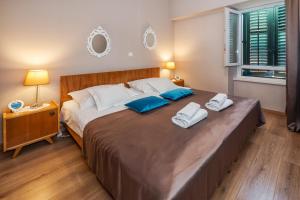 斯普利特Apartment Queen Teuta in the heart of Split historical heritage的一间卧室配有一张大床和两条毛巾