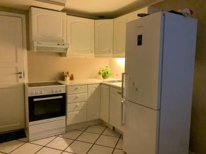 卑尔根Sentrumsnær leilighet med 3 soverom.的厨房配有白色橱柜和白色冰箱。