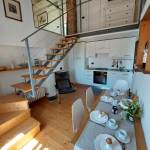 莱萨Anju d´Oro & Azzurro - Charming Apartments的厨房以及带桌子和楼梯的用餐室。