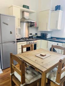 雷克瑟姆2 Bed Self Contained Apartment Wrexham的厨房配有木桌和冰箱。