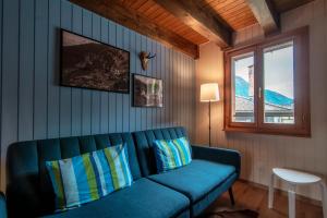 OscoCasa Bella Oschesina by Quokka 360 - in the village of Osco的客厅设有蓝色的沙发和窗户。
