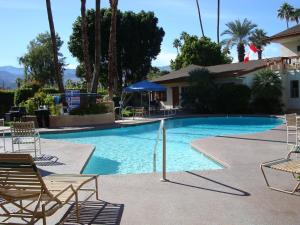 棕榈荒漠深峡谷旅馆的一座带椅子的大型游泳池和一座建筑