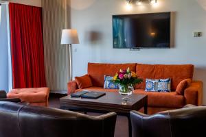 费康Hotel Le Grand Pavois的带沙发和电视的客厅