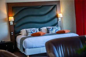 费康Hotel Le Grand Pavois的一间卧室配有一张带蓝色床头板和枕头的床。
