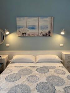 泰尔莫利Le Stanze del Centro的卧室配有一张床,墙上挂有绘画作品