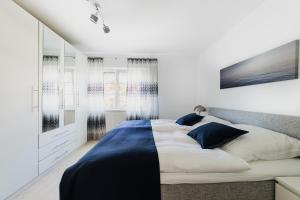 农嫩霍恩Ferienwohnung im Fischerhaus的一间卧室配有一张带蓝白色床单的大床