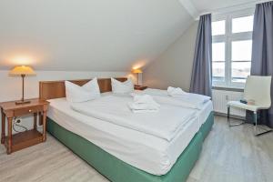 赛巴特班森Seehof Seehof 31的一间卧室配有一张带白色床单的大床