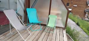 尚鲁斯Appartement avec terrasse à proximité des pistes的甲板上摆放着两把蓝色和绿色的椅子