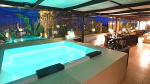 莱切圣基娅拉套房酒店的一个带餐厅的房间中的一个大型游泳池