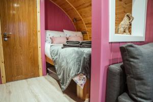 StewartonFulshaw Mill Holidays的粉红色客房内的一张床位