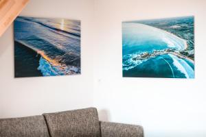 庞马尔APPART-DUPLEX VUE MER PANORAMIQUE BALCON & PISCINE proche commerce的客厅的沙发,墙上有两张照片
