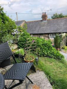Llanrhaeadr-ym-MochnantAnnie’s Cottage的一个带桌椅的花园以及一座房子