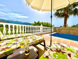 弗里希利亚纳Villa Nuria的一个带桌子和遮阳伞的庭院和一个游泳池