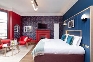 爱丁堡30 Castle Street Deluxe Apartments的卧室拥有蓝色和红色的墙壁,配有一张床