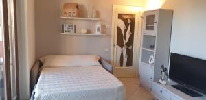 雷卡纳蒂港CLARE HOUSE per una vacanza "CHIC"的小房间设有一张床和一台平面电视