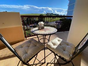 雷卡纳蒂港CLARE HOUSE per una vacanza "CHIC"的露台的阳台配有桌子和两把椅子