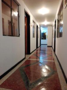波哥大CASA HOTEL VICTORIA Av 30的大楼内铺有瓷砖地板的走廊