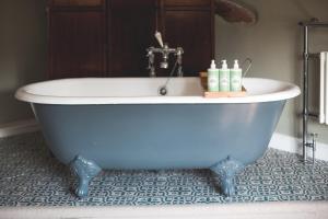 Barford Saint MichaelThe George Inn的浴室设有蓝色浴缸。