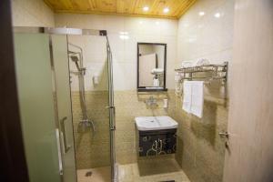 安曼Grape Village Hotel的一间带玻璃淋浴和水槽的浴室