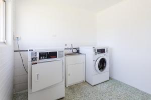 布里斯班温纳姆安可汽车旅馆的洗衣房配有洗衣机和烘干机