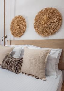 阿波罗尼亚Mantelena studios & family apartments的一间卧室配有一张带白色枕头的床和两面镜子