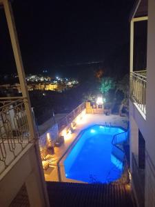 博德鲁姆爱琴海门酒店的游泳池在晚上在建筑物的阳台上