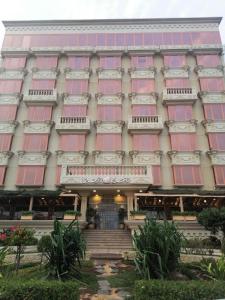 吉赞Al-Borg Hotel的一座建筑,拥有红色和粉红色的窗户和楼梯