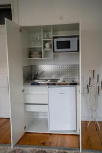 SchwanbergFerienwohnung Sandwirtin的厨房配有白色橱柜和微波炉