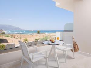 玛利亚Pyrgos Blue的一间配备有桌椅的用餐室,享有海滩美景